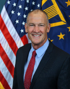 Image of BG Papenfus posing in front of the United States flag and the Brigadier General flag.