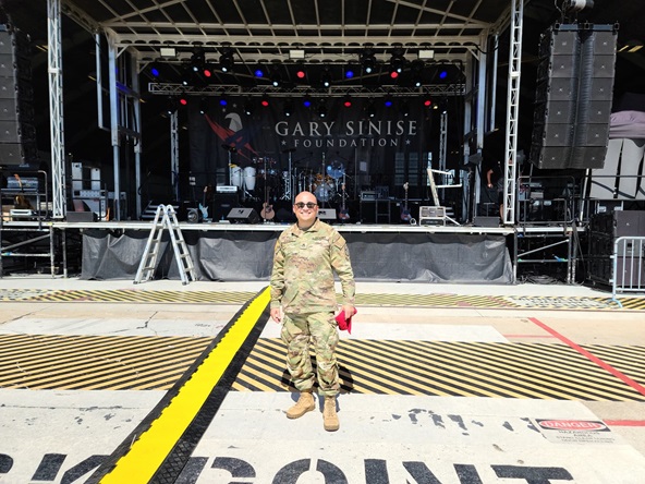 Image of Army Staff Sgt. Emmanuel Angulo posing in front of the Gary Sinise Foundation stage at MacDill Air Force Base, July 8, before a Lt. Dan Band performance. (DISA photo by Army Staff Sgt. Emmanuel Angulo)
