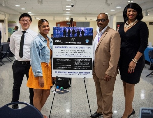 Image of Joint Service Provider personnel posing with a Cyber Awareness Forum poster. (DISA photo by Joanne Sorrentino)