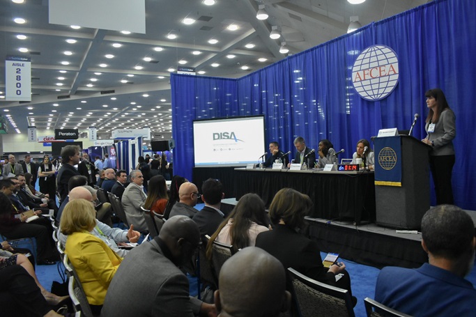 Wide view of DISA's Small Business Elevator Pitch contest with panel, contestant and audience in picture.
