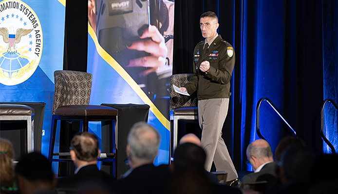 Photo of Army Lt. Gen. Paul T. Stanton facing towards the left while on stage. Infront of the stage are the back of the heads of several attendees.